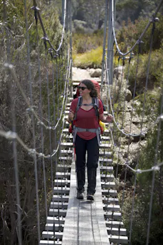 A woman walking on a hanging bridge