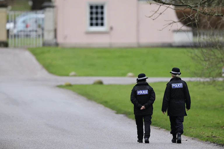 View from behind of two police officers walking down a path
