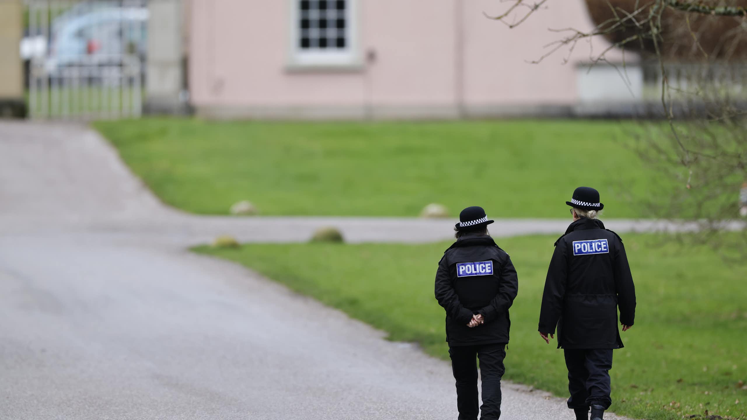 View from behind of two police officers walking down a path