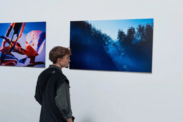 A person looking at in-game photography in a gallery