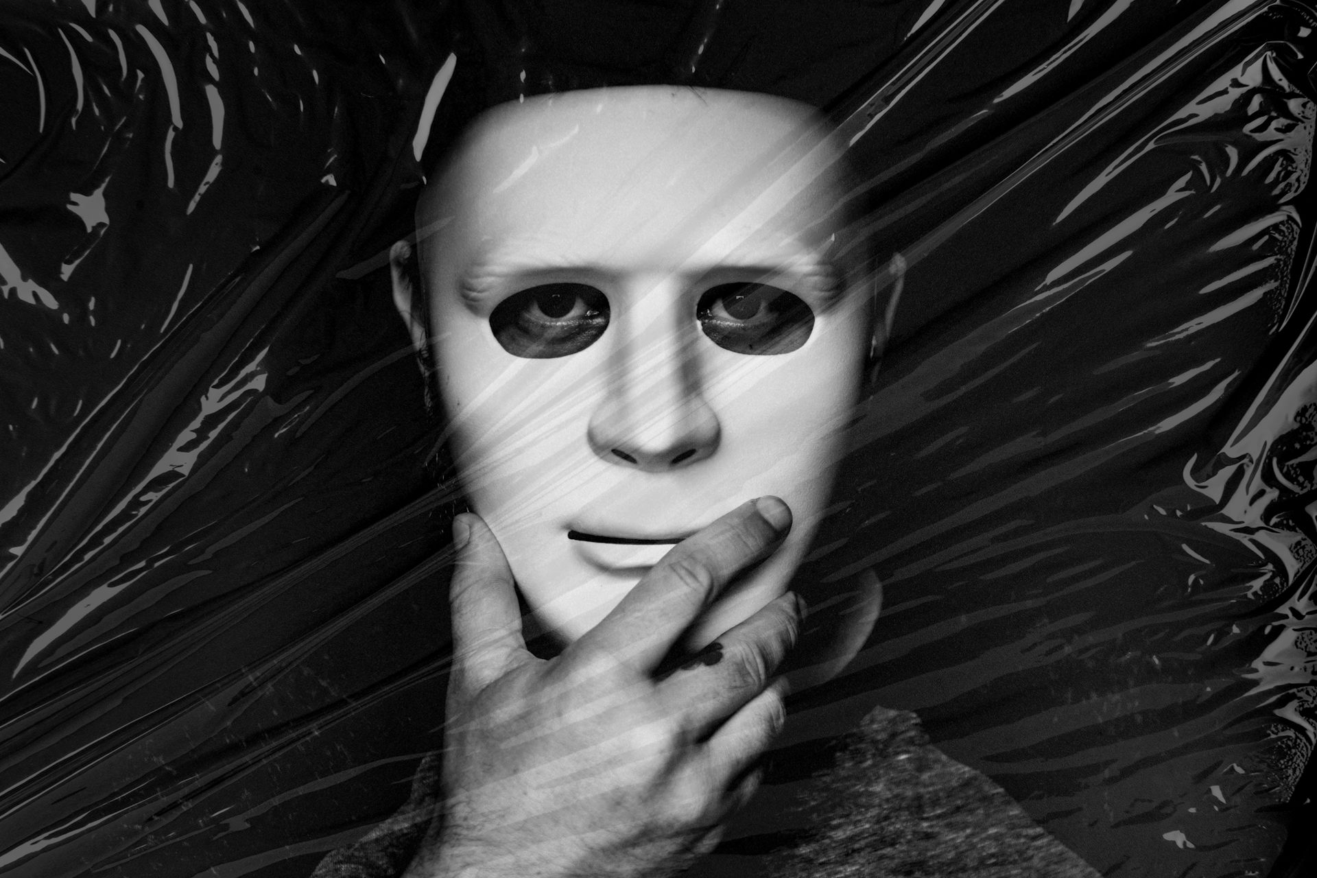 Man holding white mask over his face