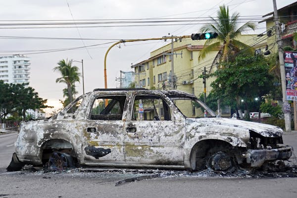 A burned car is seen on a street.