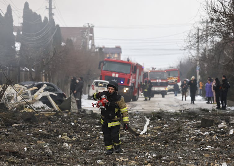 Ukrainian rescuers work at the site of a Russian strike in Kyiv.