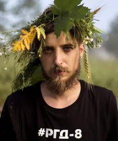 A young Ukrainian soldier with flowers in his hair.