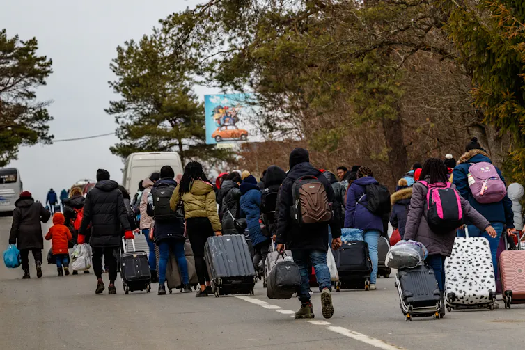 Ukrainian refugees carry their belongings as they approach the Slovakian border.