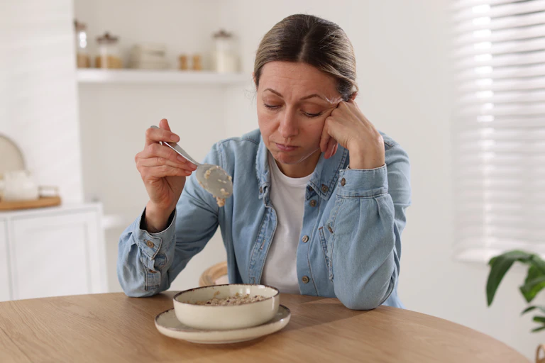 Woman with no appetite eats cereal