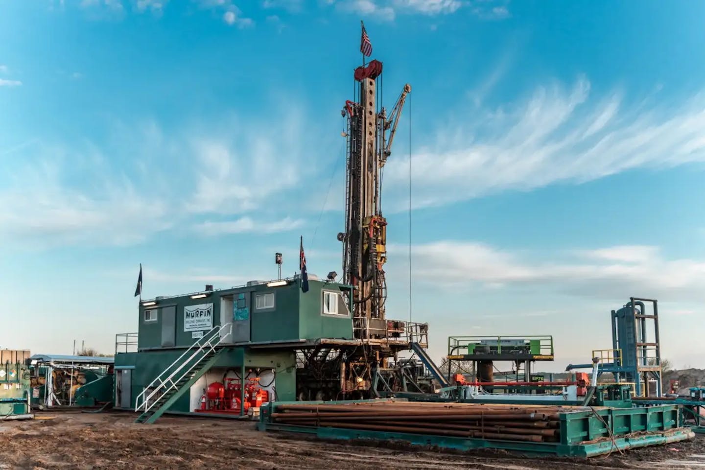 A large drill rig sits on open ground.