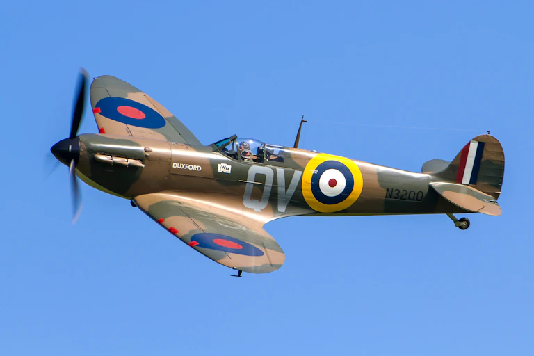 A spitfire flying through a blue sky.
