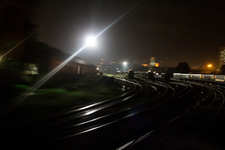 The scene at a train train station after nighfall.