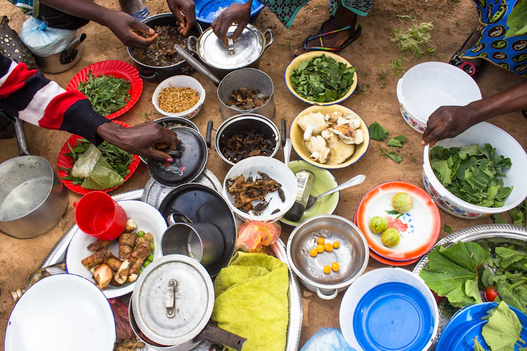 View from above of pots and plates of food, and some hands
