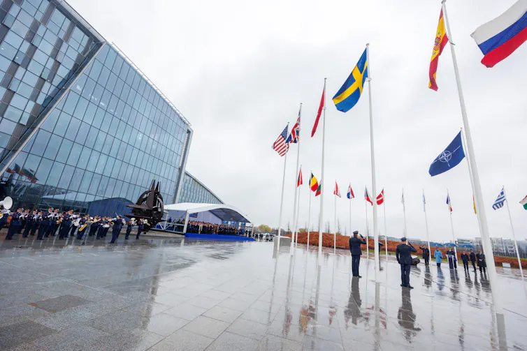 sweden's flag hanging alongside those of other nato member states outside nato hq in brussels, belgium