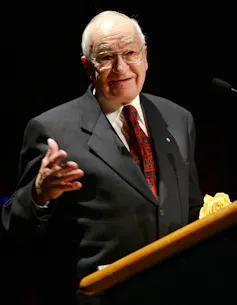 A man at a podium in suit.