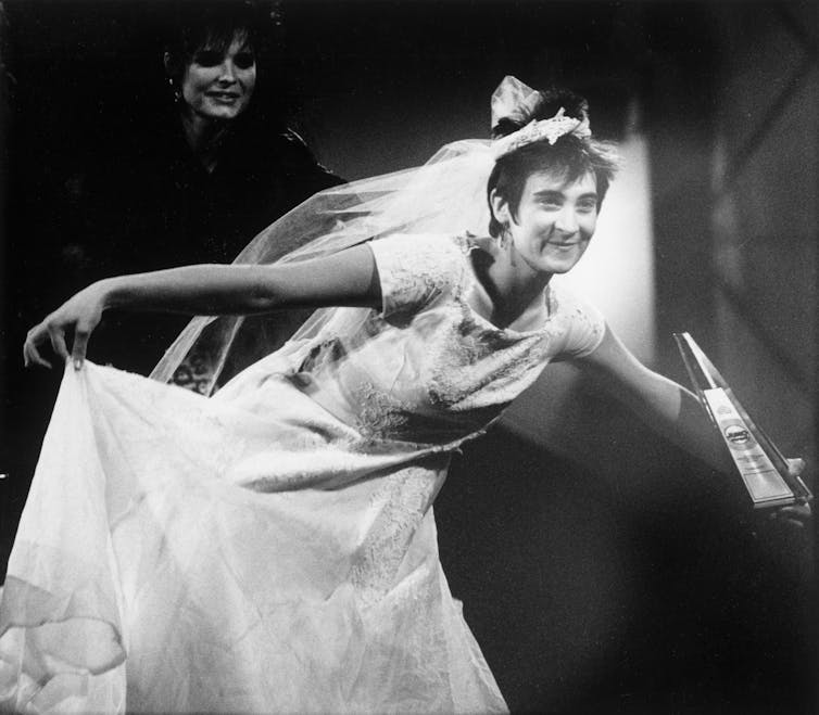 Cómo los Junos ayudaron a definir la industria musical canadiense 2 Una persona con un vestido de novia blanco en el podio de premios.