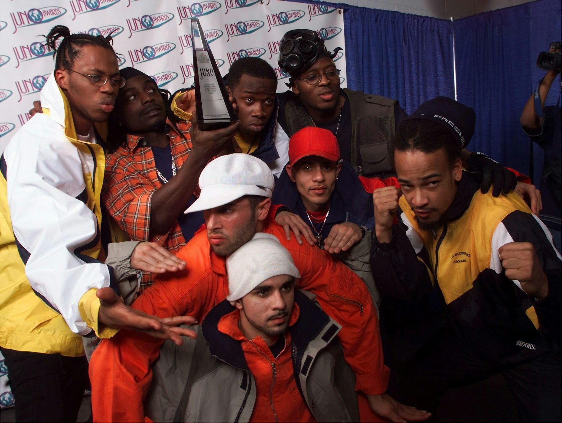 Un grupo de artistas se agachó y se reunió para posar para una foto, algunos en la parte de atrás sosteniendo la estatua.