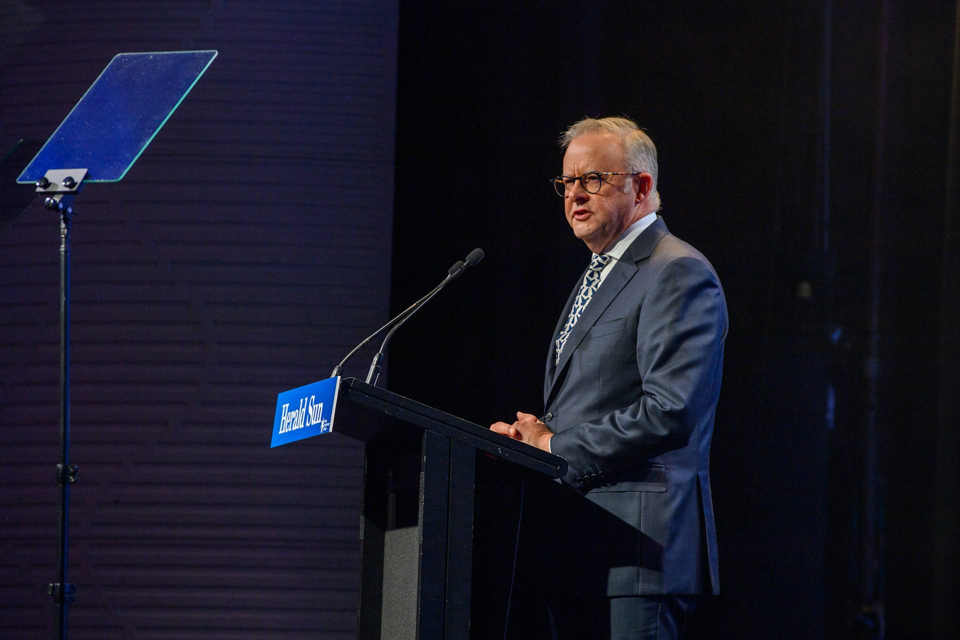 Anthony Albanese stands at a lectern and addresses a crowd