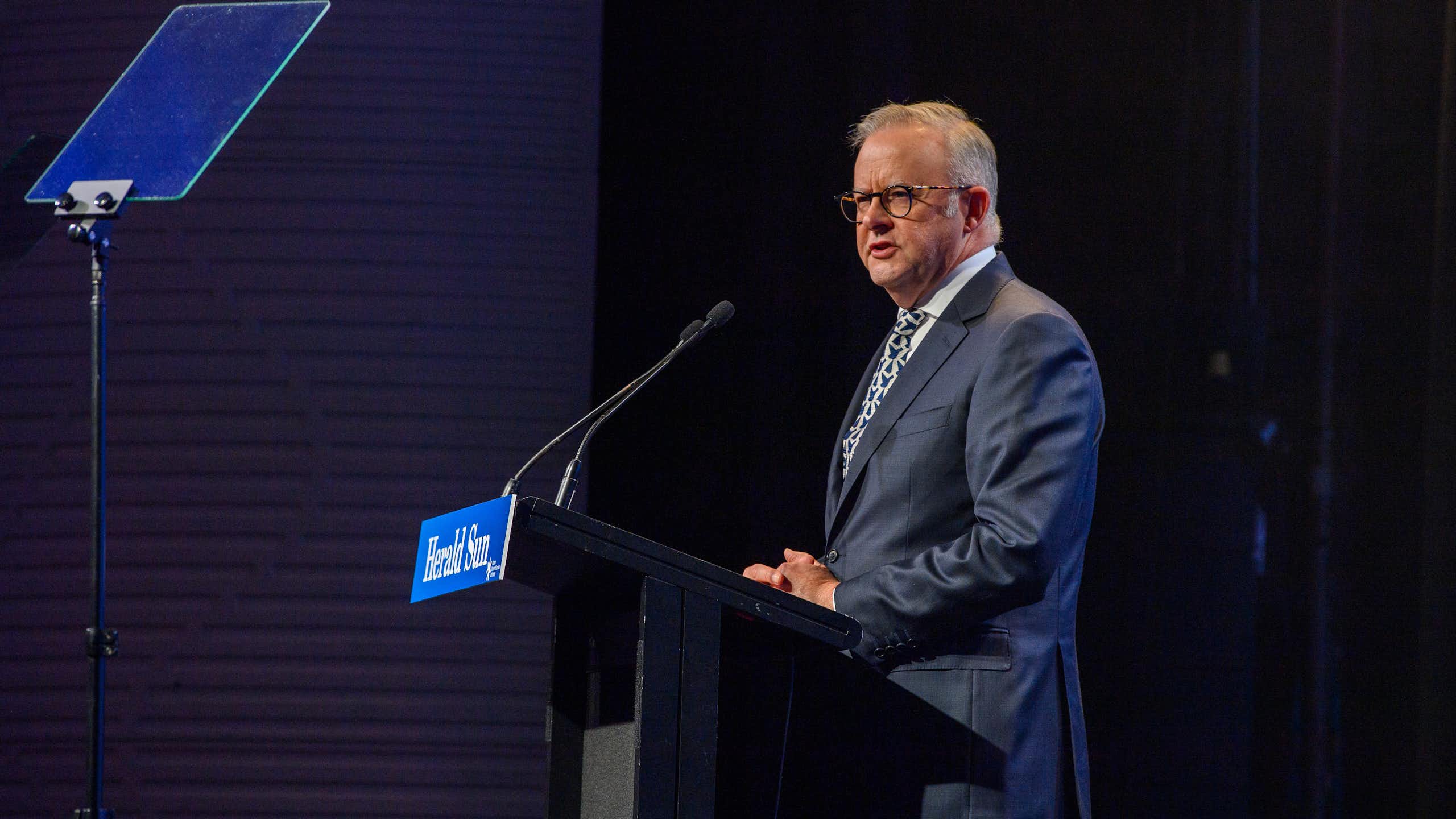 Anthony Albanese stands at a lectern and addresses a crowd