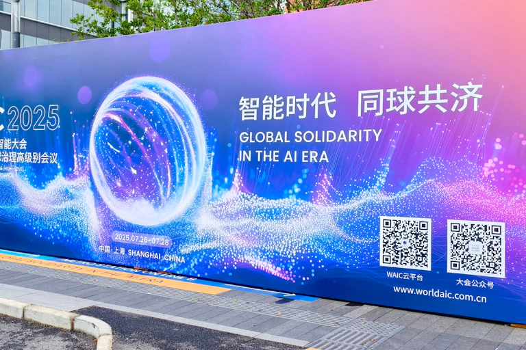 A billboard showing English text reading GLOBAL SOLIDARITY IN THE AI ERA with Chinese text and computer graphics