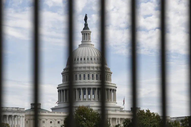 US Capitol pictured through the bars of a fence
