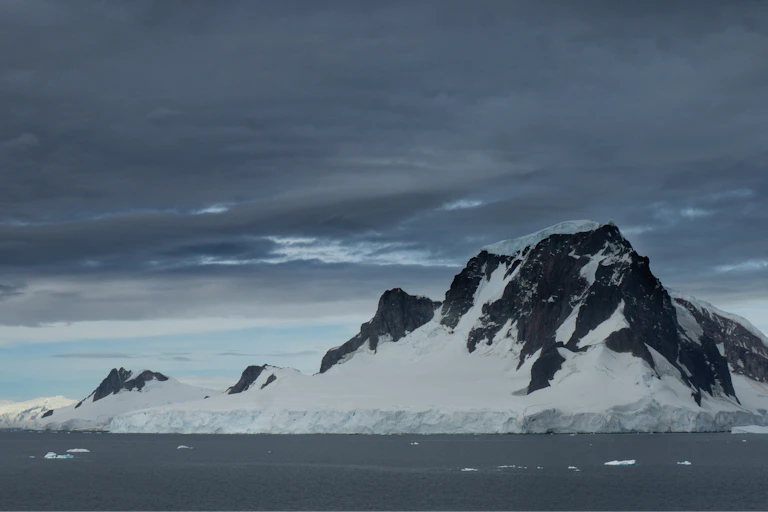 Montanha antártica com nuvens acima