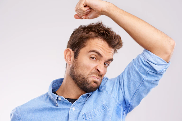 Homem com marcas de suor na camisa ao redor das axilas