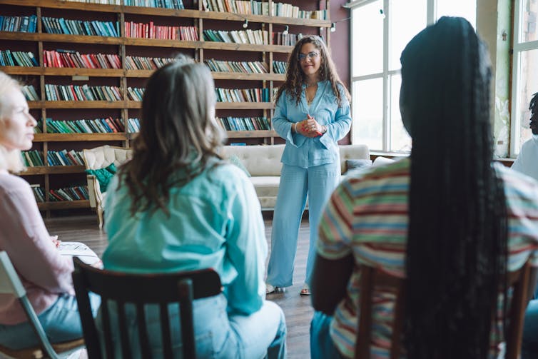 woman standing in front of others during group therapy session