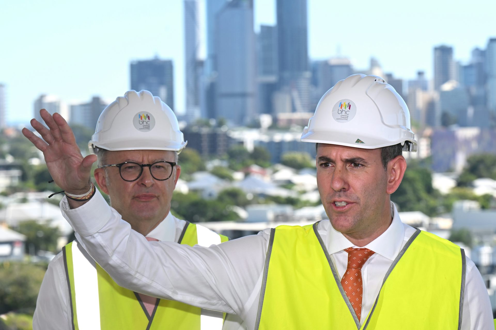 Two men in ties and hard hats in front of a Melbourne skyline: Anthony Albanese and Jim Chalmers
