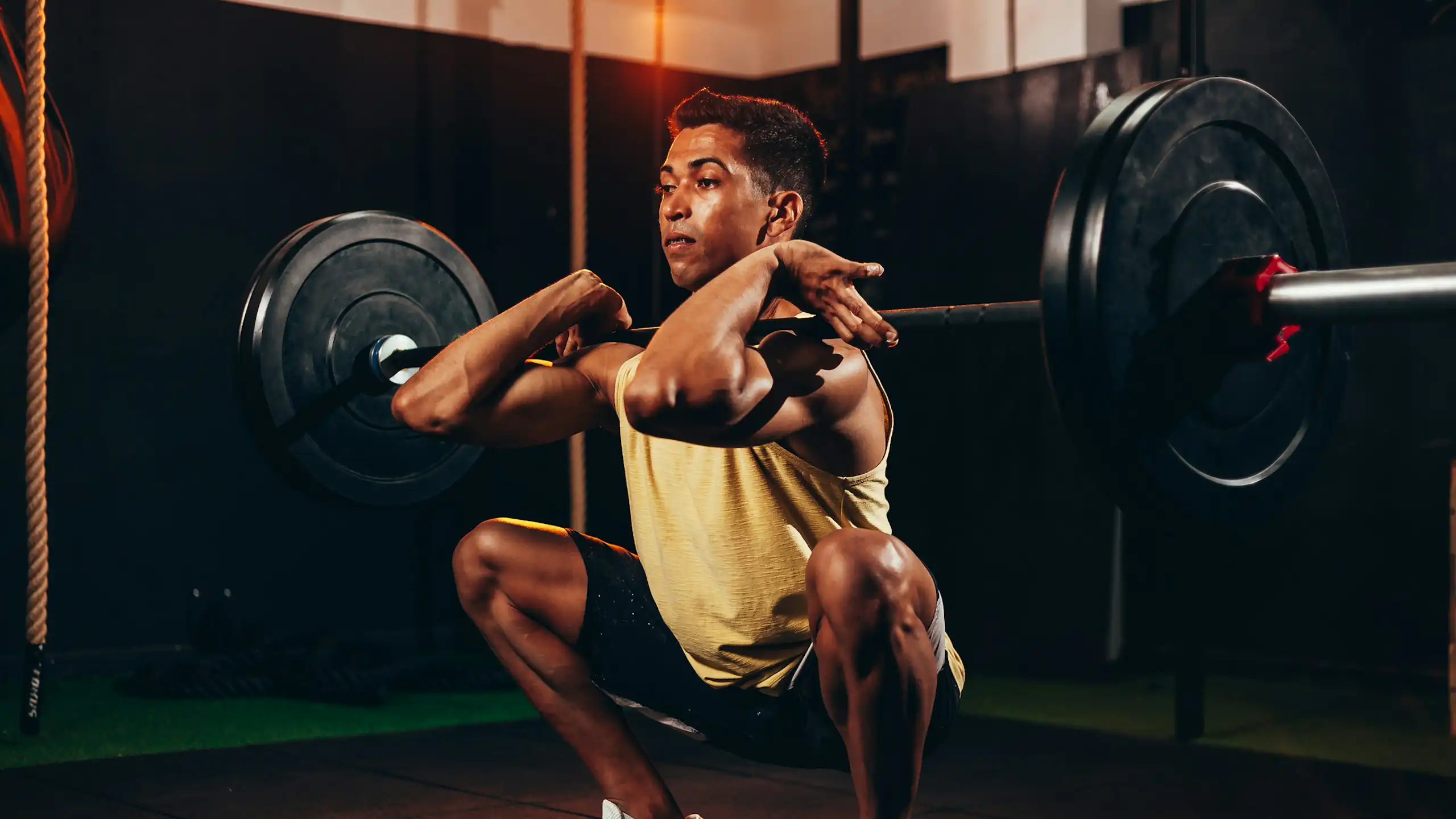 Man squats while lifting heavy weights.