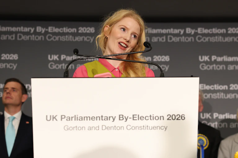 Spencer speaking at the podium with other byelection candidates onstage in the background