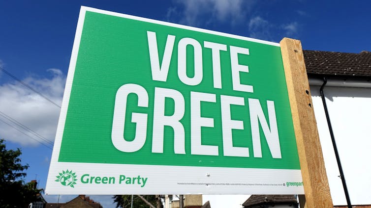 vote green sign, outside blue sky