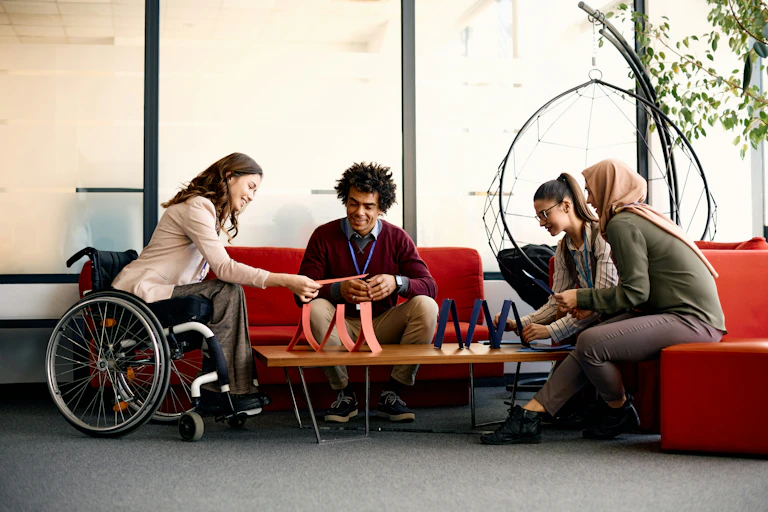 A group of differently abled people sitting around a table and having a conversation.