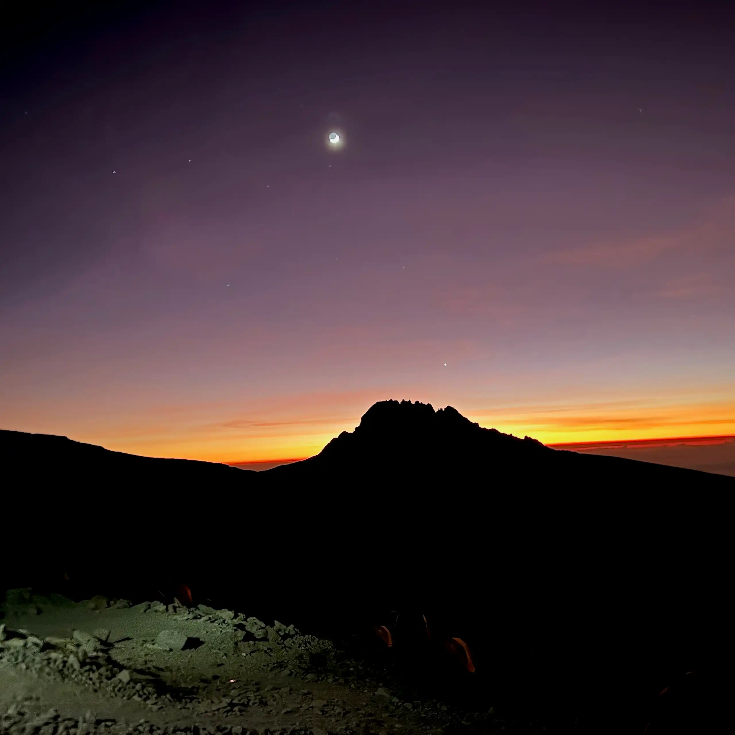 A landscape against a purple sky and breaking dawn