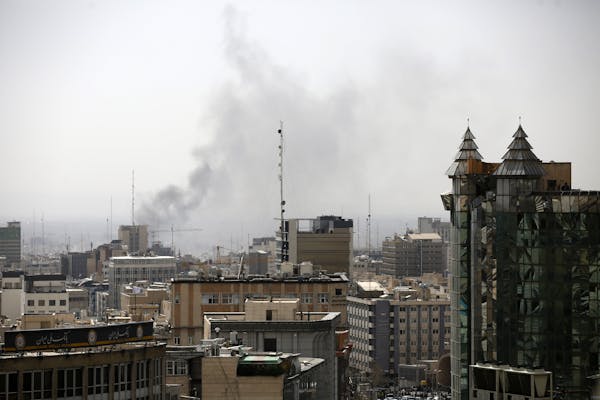 Smoke rises over a city center.
