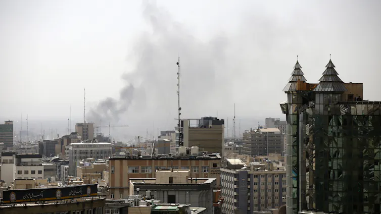 Smoke rises over a city center.