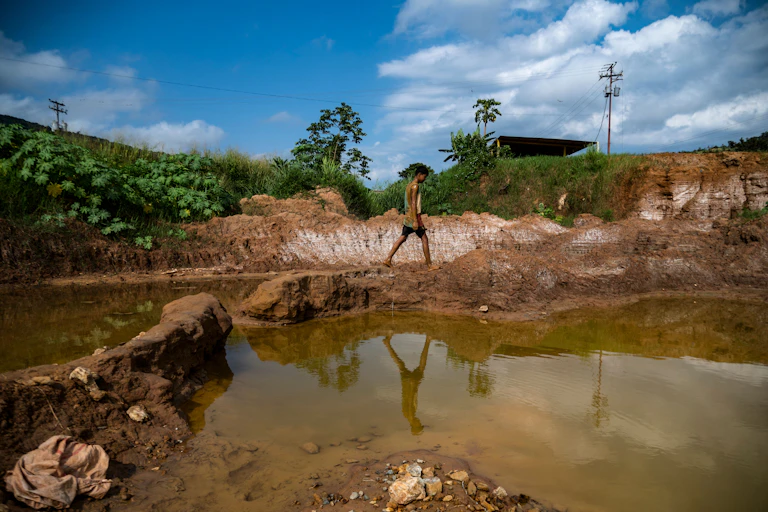 A young Venezuelan miner works in an open pit gold mine in Bolivar State, Venezuela, in 2023.
