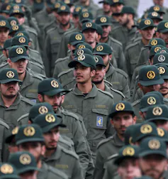 Des rangées d’hommes en uniformes militaires et casquettes