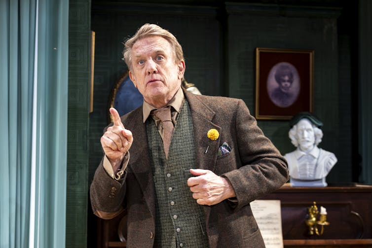 Burke on stage in a nice suit.