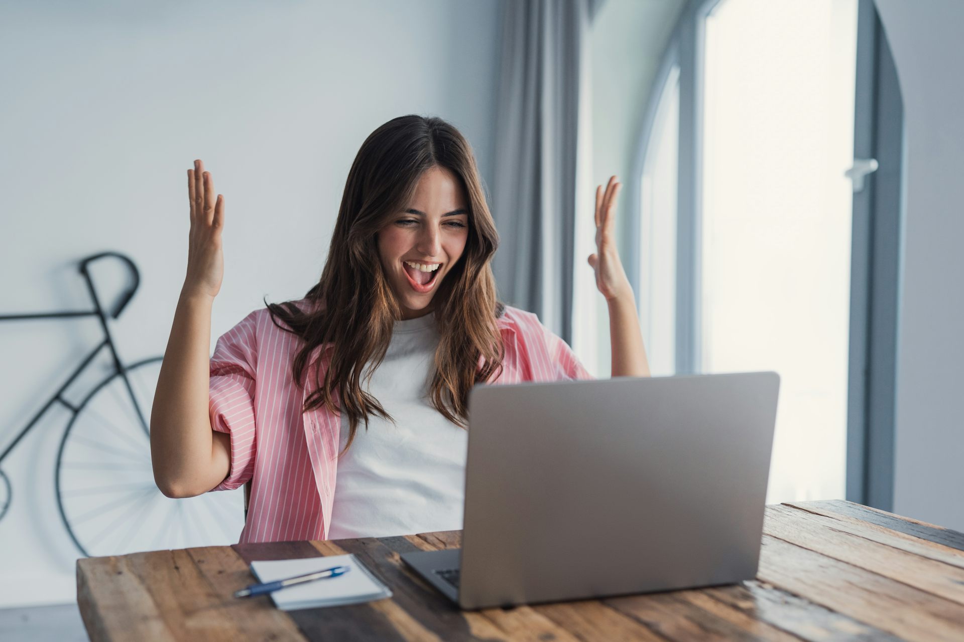 An awe-struck young woman looks at her computer.