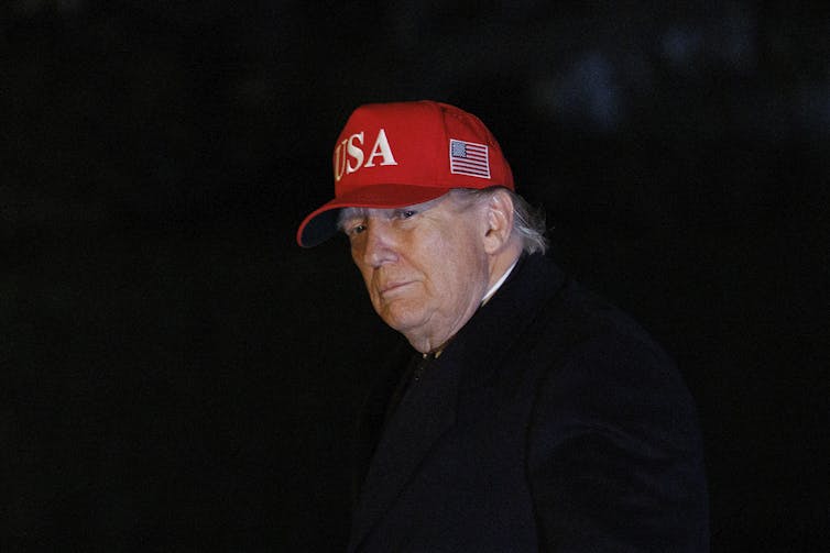 Donald Trump wearing a red baseball cap.