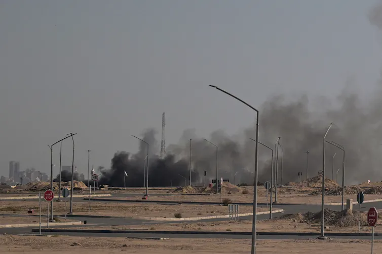 Smoke rises from buildings.