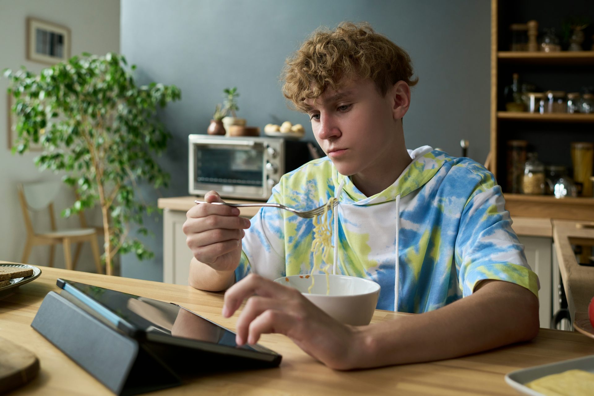 Boy on tablet while eating