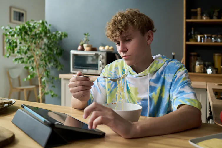 Boy on tablet while eating