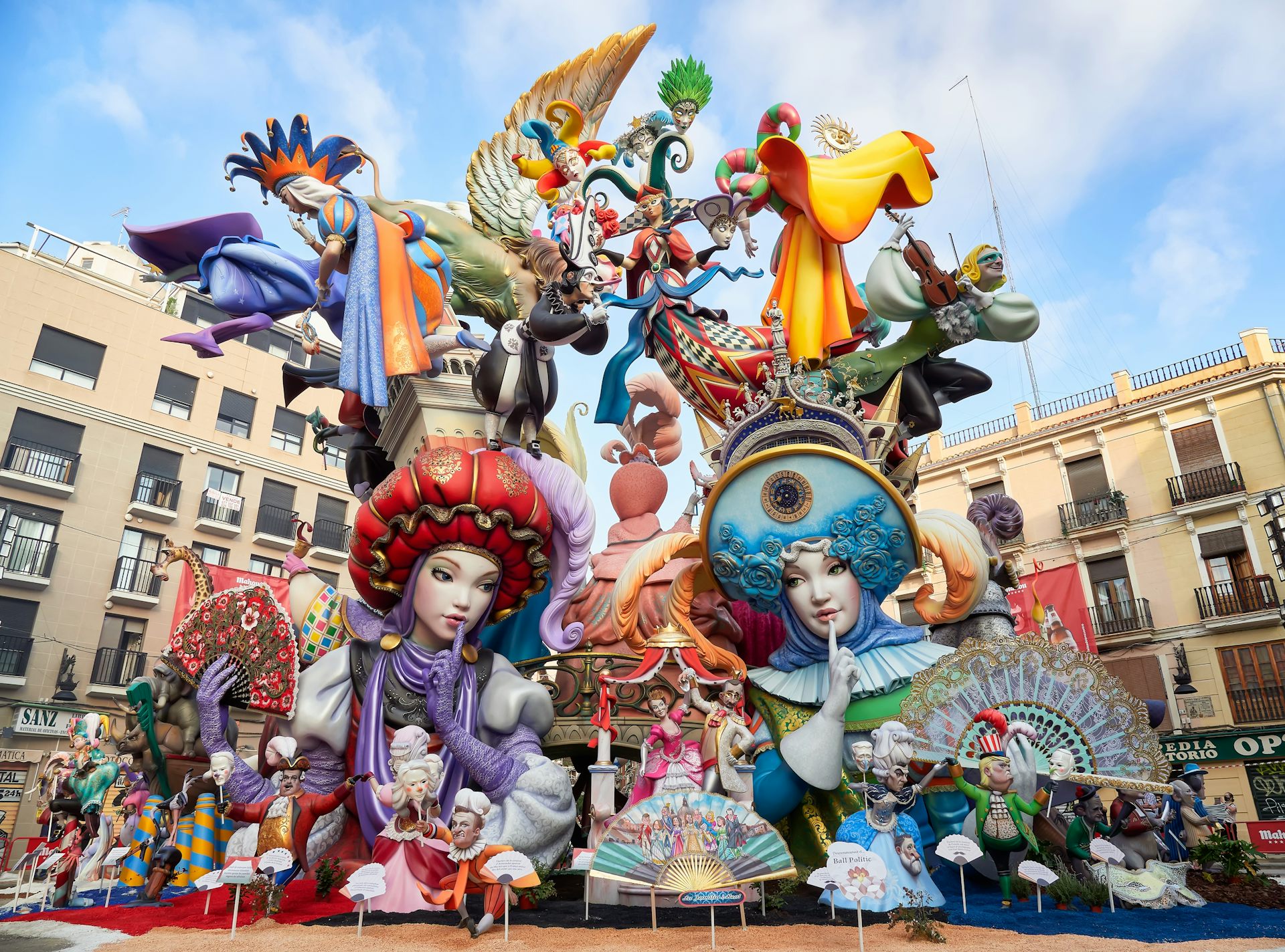 La falla té dos ninots centrals vestits de moro i cristià que es miren amb el dit a la boca, fent-se callar. Molts altres ninots més xicotets, dalt, representen personatges referents a festes populars, música o balls tradicionals.