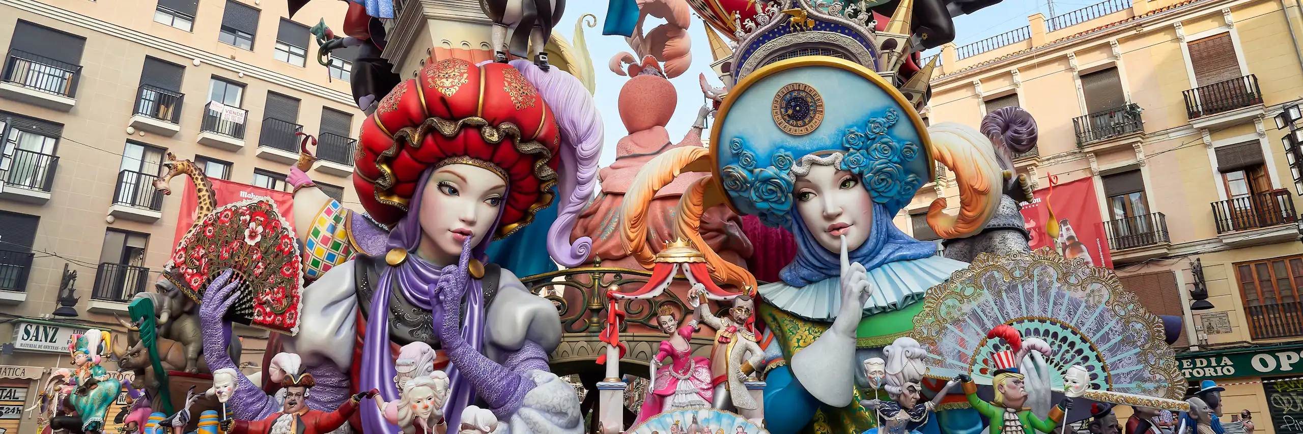 La falla té dos ninots centrals vestits de moro i cristià que es miren amb el dit a la boca, fent-se callar. Molts altres ninots més xicotets, dalt, representen personatges referents a festes populars, música o balls tradicionals.