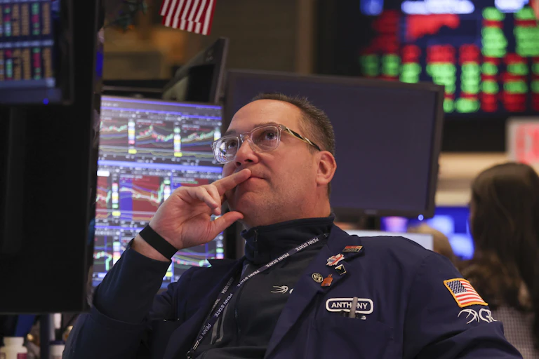 a trader at the new york stock exchange studies prices on a monitor after the opening bell on monday.