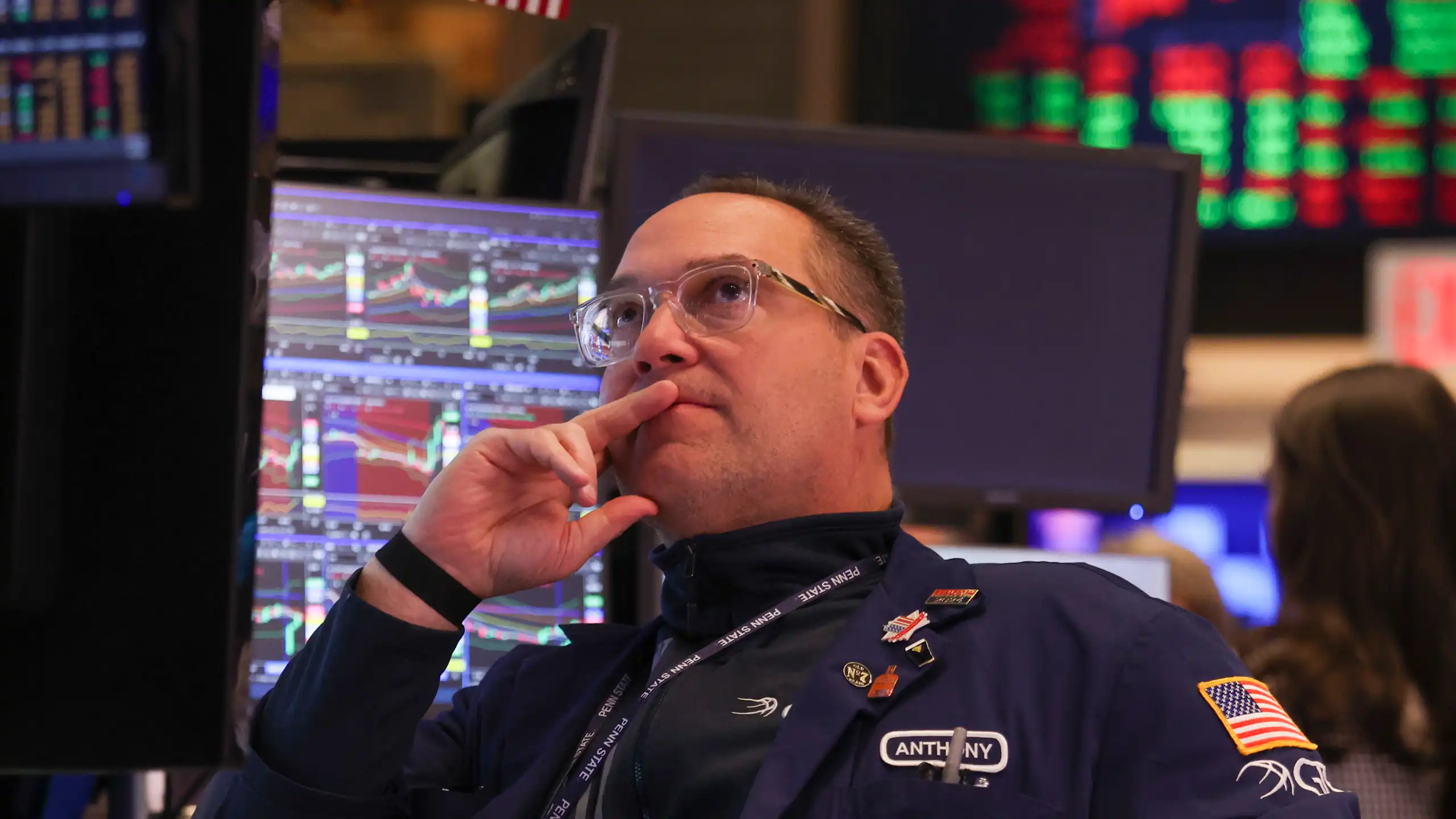 a trader at the new york stock exchange studies prices on a monitor after the opening bell on monday.
