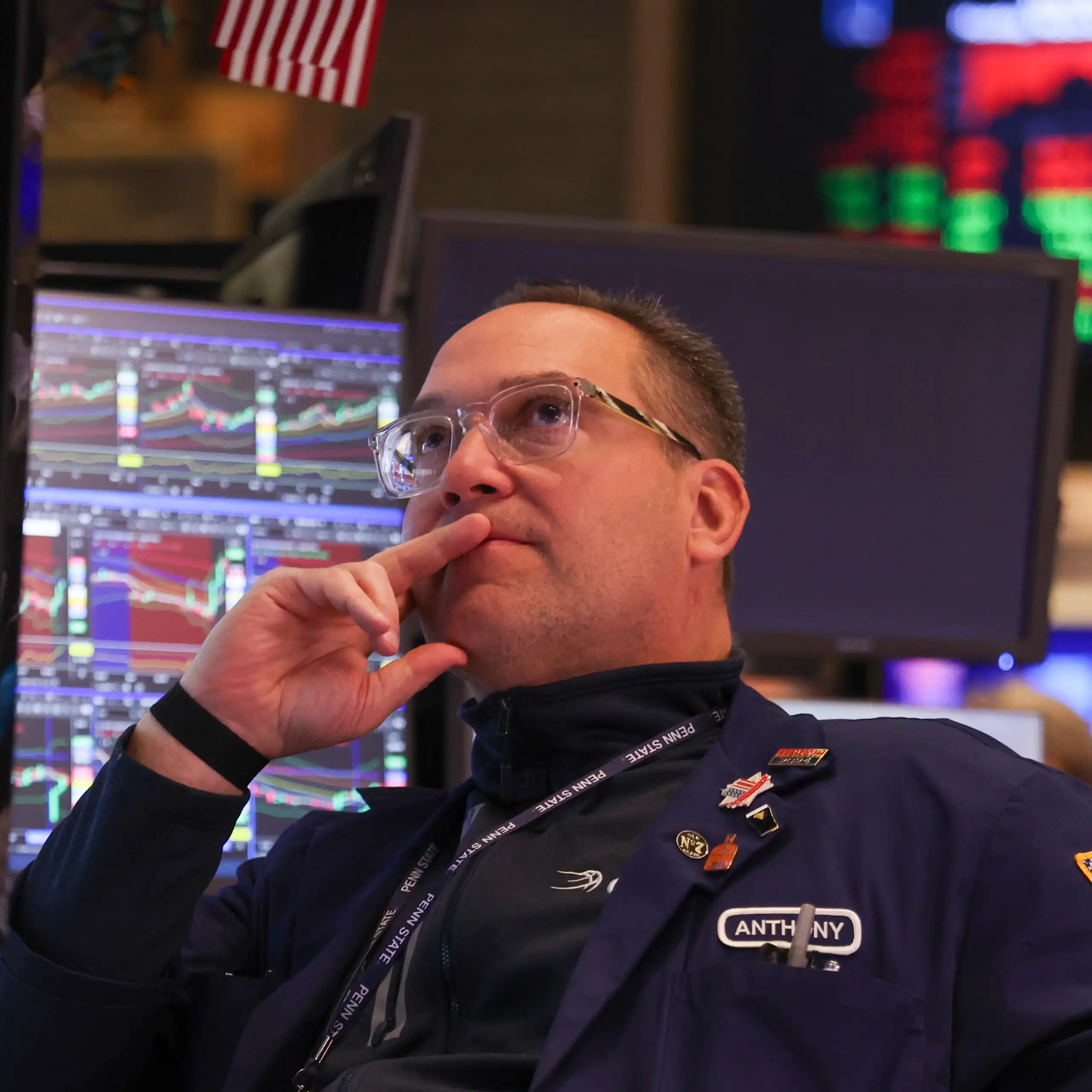 a trader at the new york stock exchange studies prices on a monitor after the opening bell on monday.
