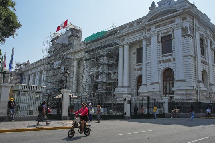 La destitución del presidente de Perú apunta a una crisis más profunda 1 edificio blanco con andamios. La bandera peruana ondea arriba.