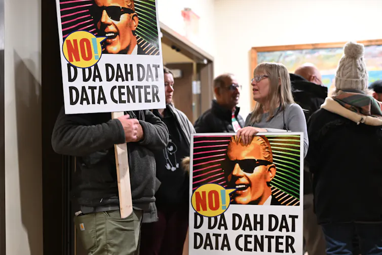 People hold signs that say 'No! D Da Dah Dat Data Center'