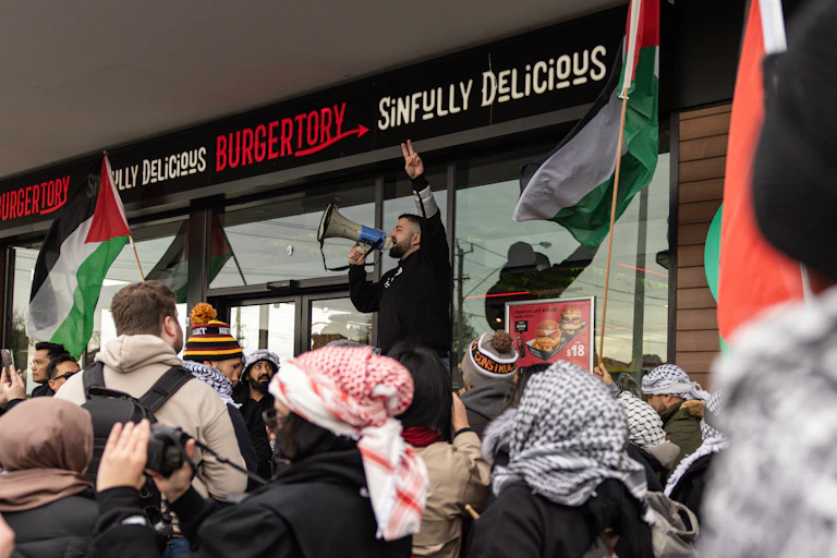A man addresses a pro-Palestinian protest by speaking into a megaphone