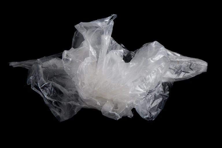 Crumpled up plastic wrap against a black background